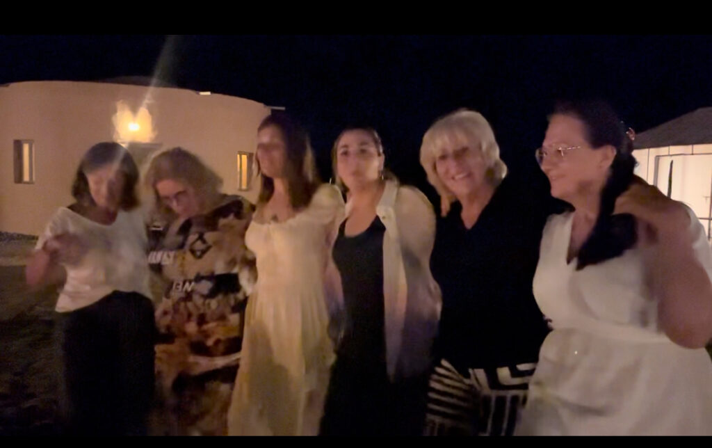 Groupe d’amis dansant autour du feu lors d’un anniversaire au Bivouac Luna